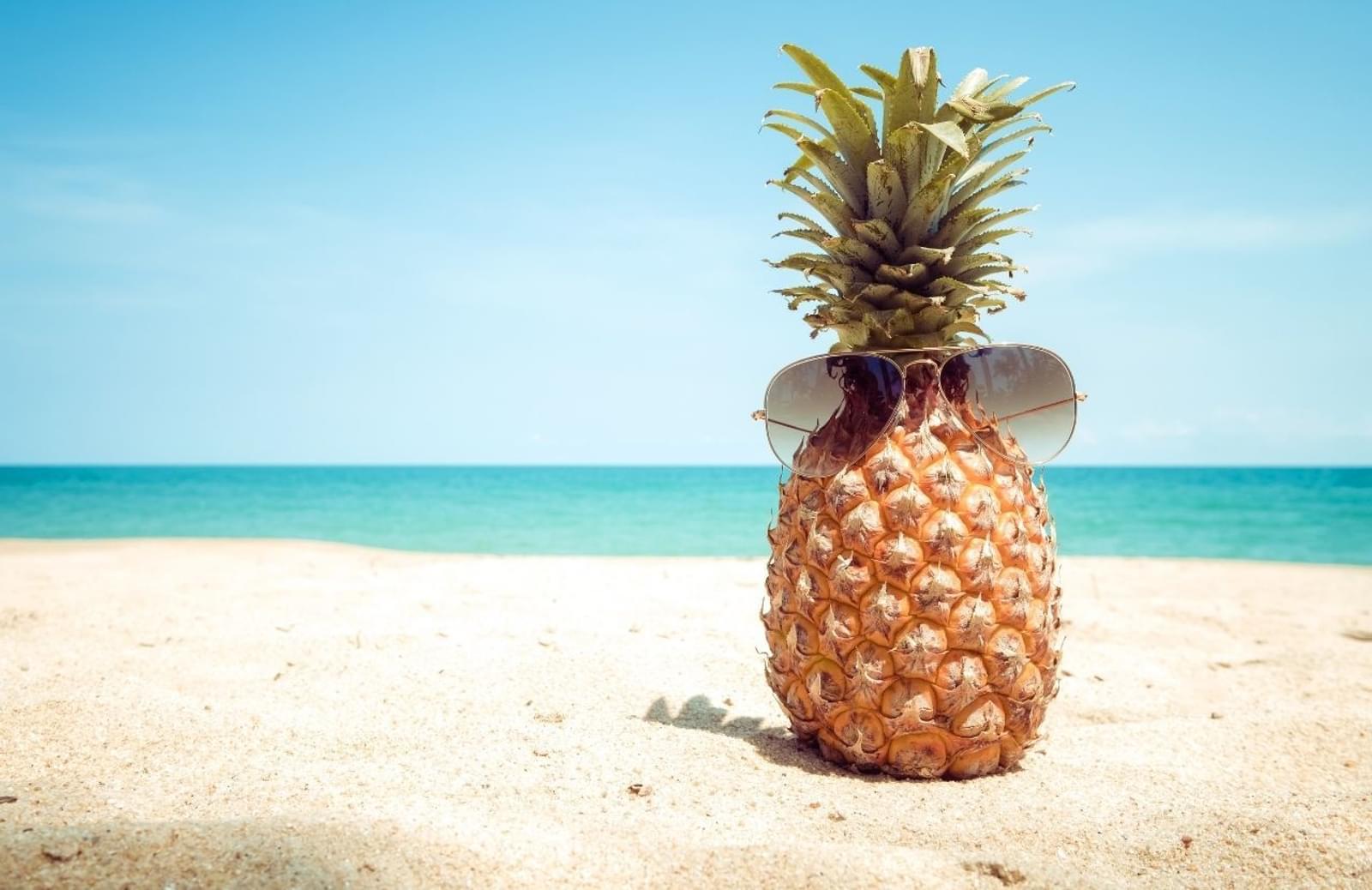 Pineapple wearing subglasses on a sunny beach