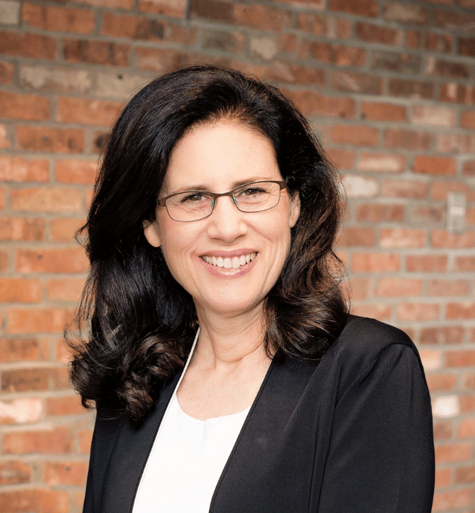 Carol Fishman Cohen Brick Background Headshot Close Distance