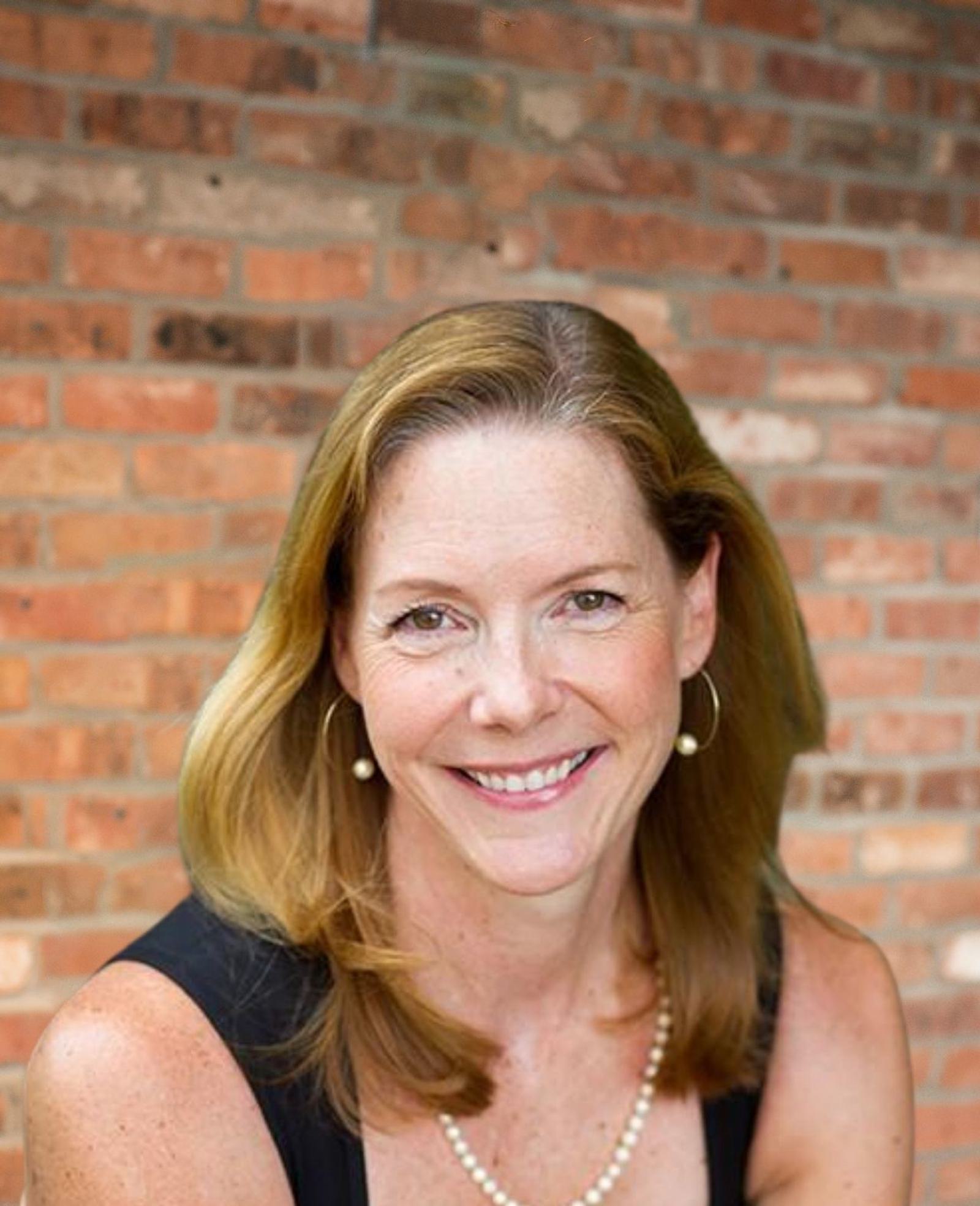 Jennifer Howland Headshot in front of brick background
