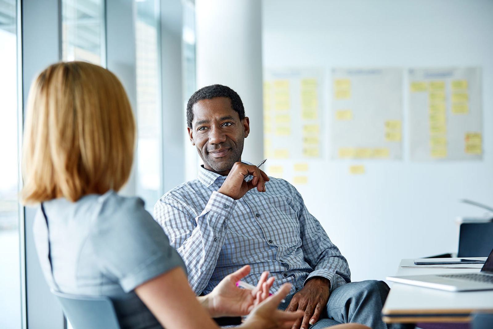 Career coach meets with client in office setting business discussion.jpg