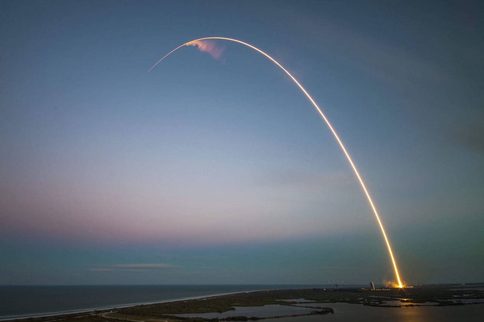 A rocket launches into the sky leaving a trail of light in its path