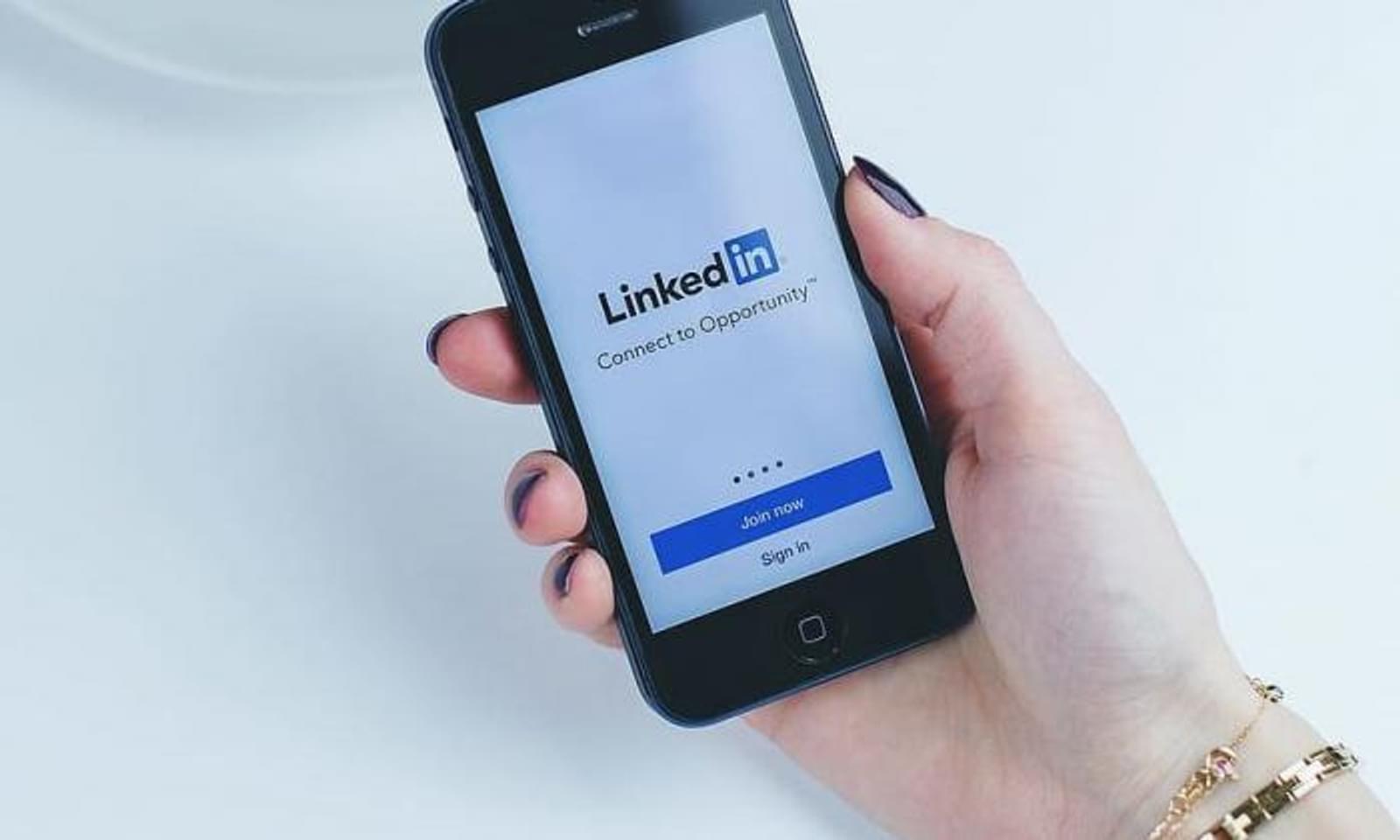 Person holding cellphone with LinkedIn login page on screen