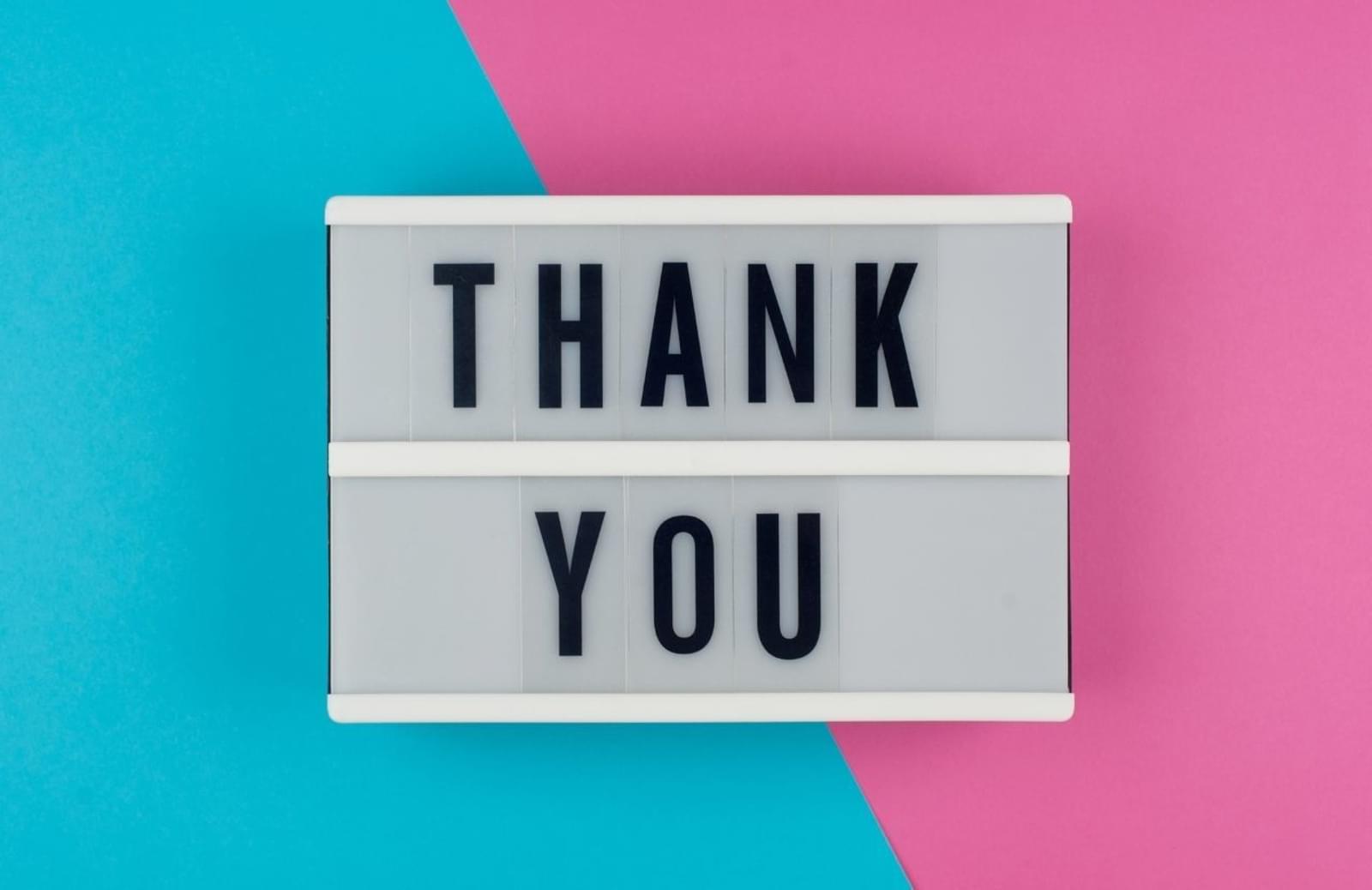 Pink and blue background with a sign saying "thank you"