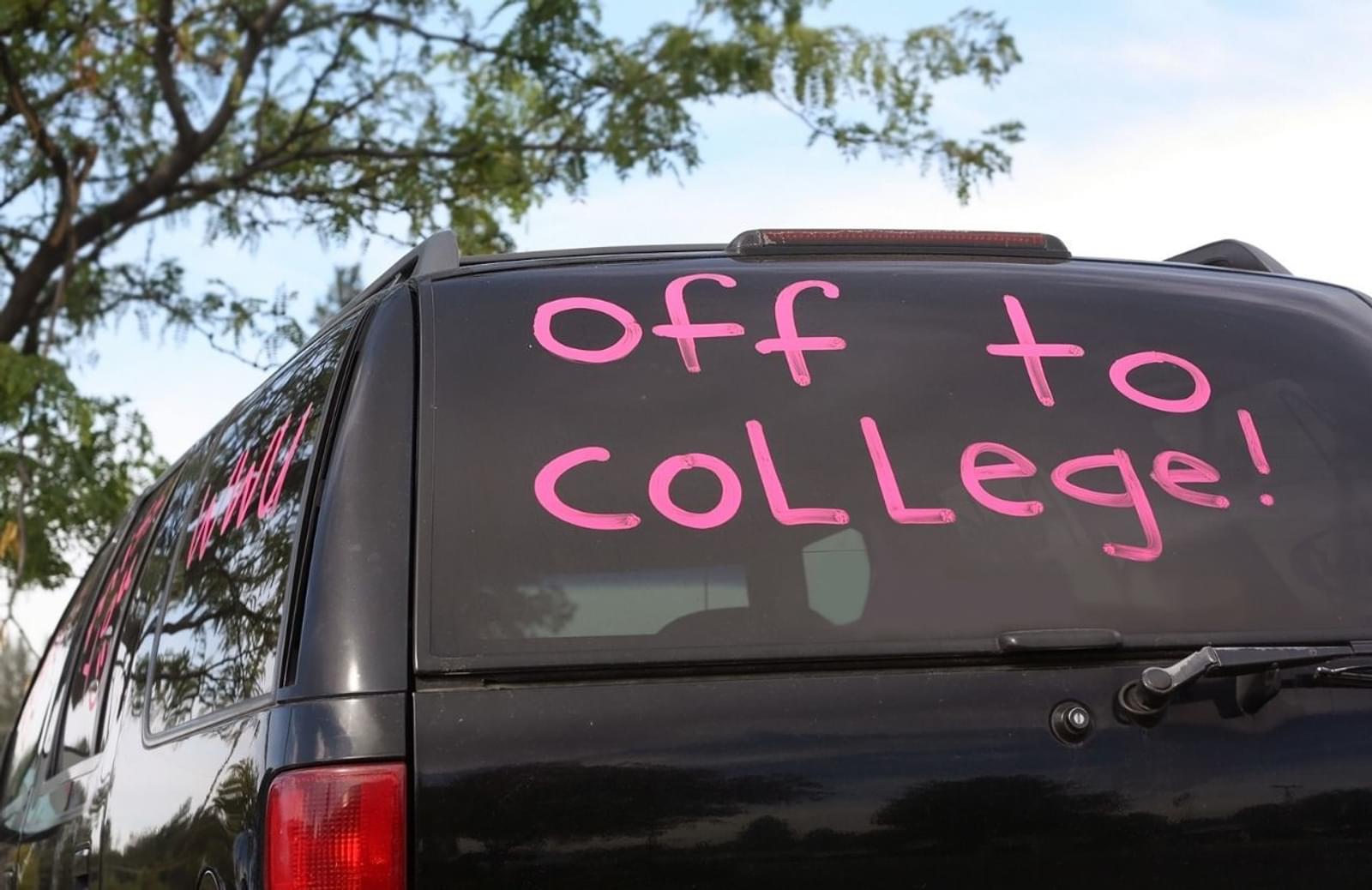 Black SUV with the words "off to college!" written in pink on window
