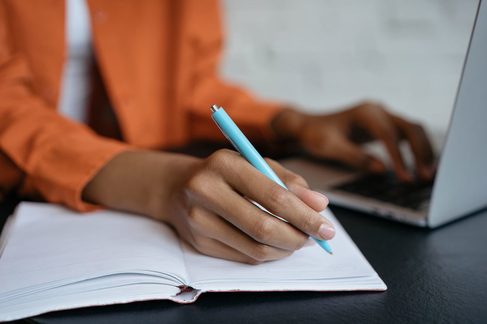 Hand holding pen writing in notebook