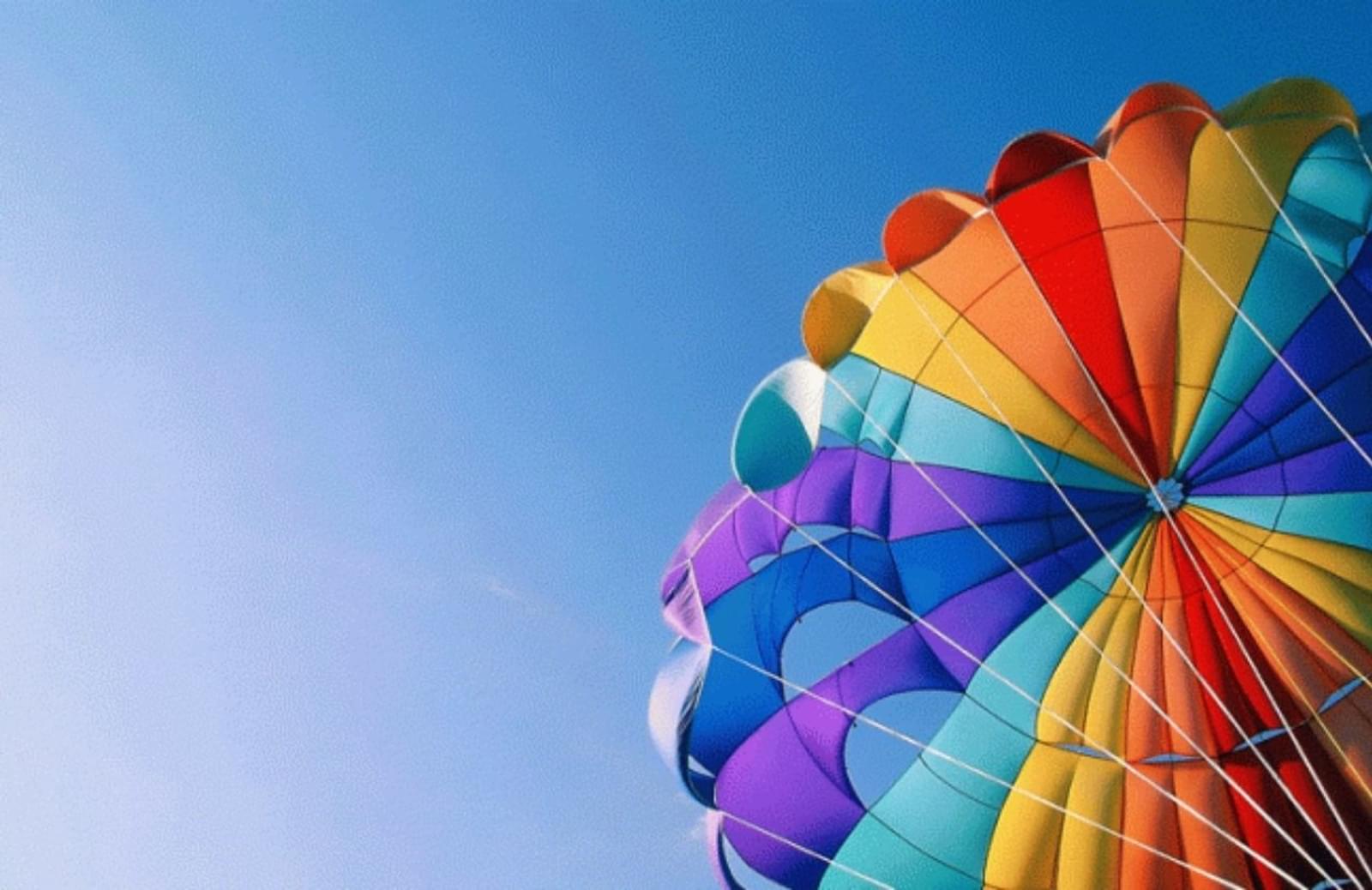 Colorful open parachute against a blue sky