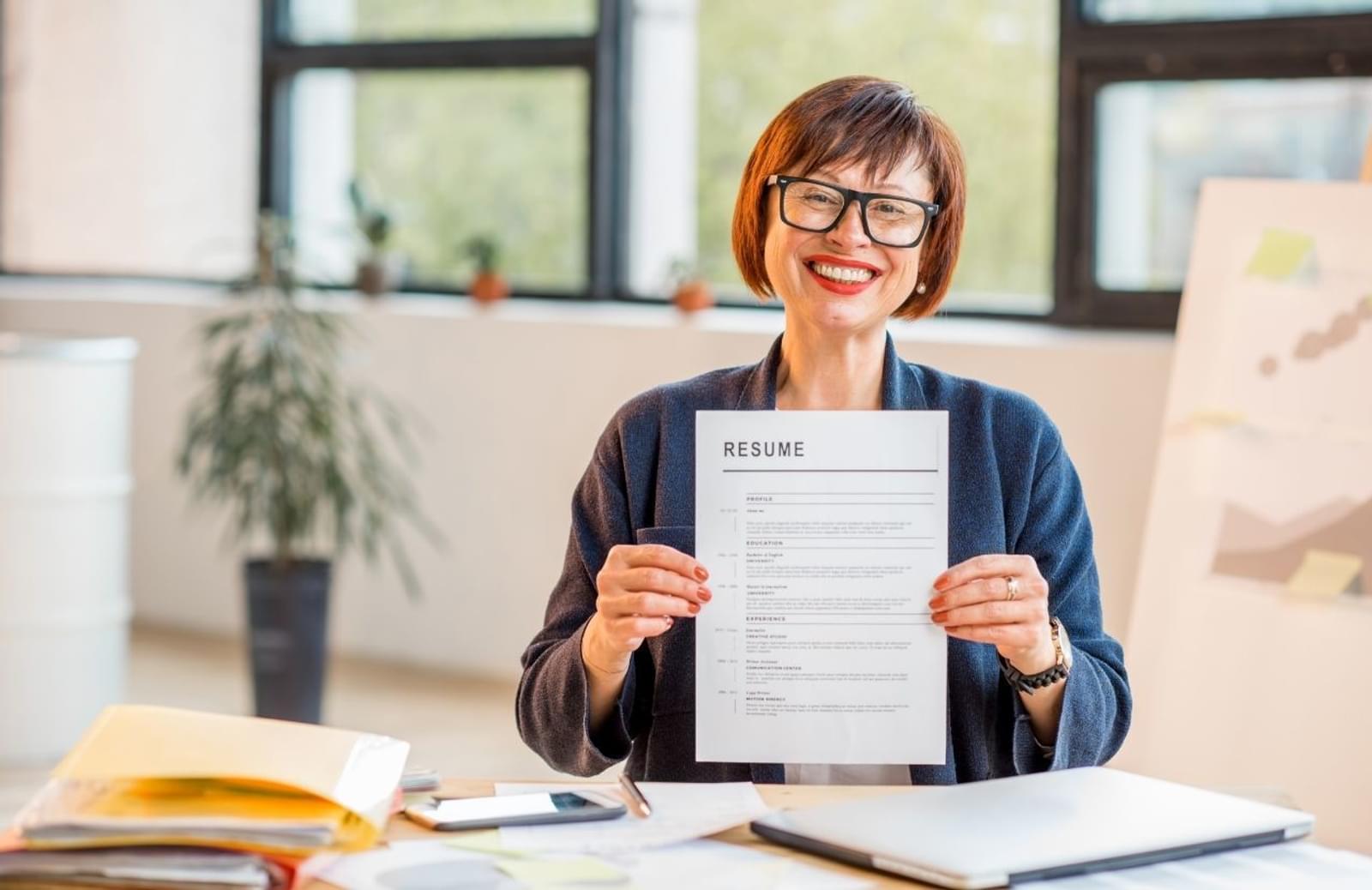 smiling woman holding up resume
