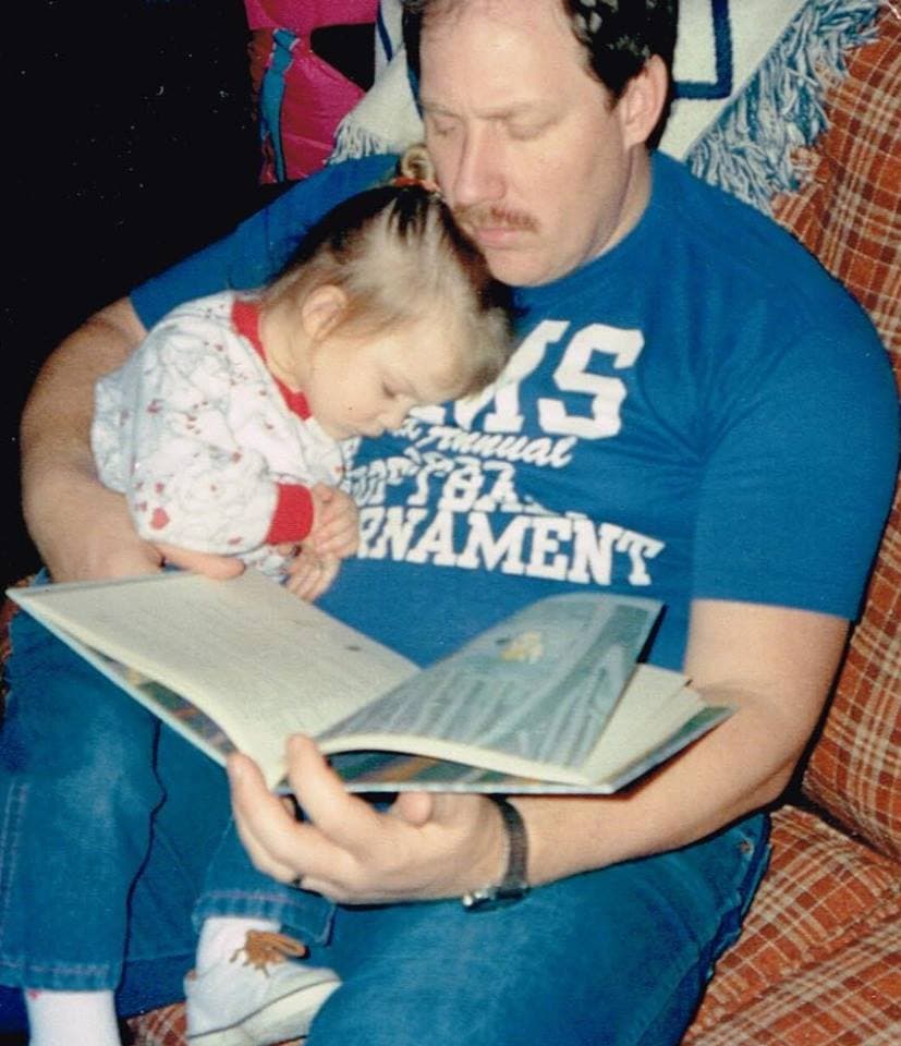 Shannon Amspacher's father reads to a sleeping Shannon as a toddler