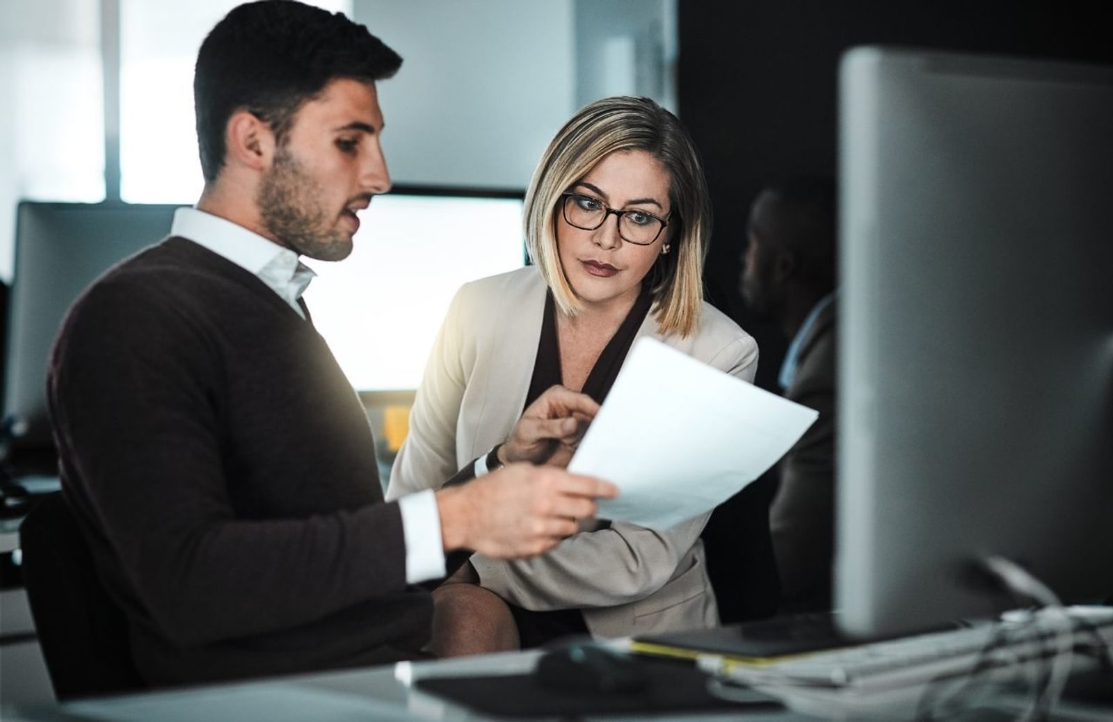 Business man showing a document to business woman